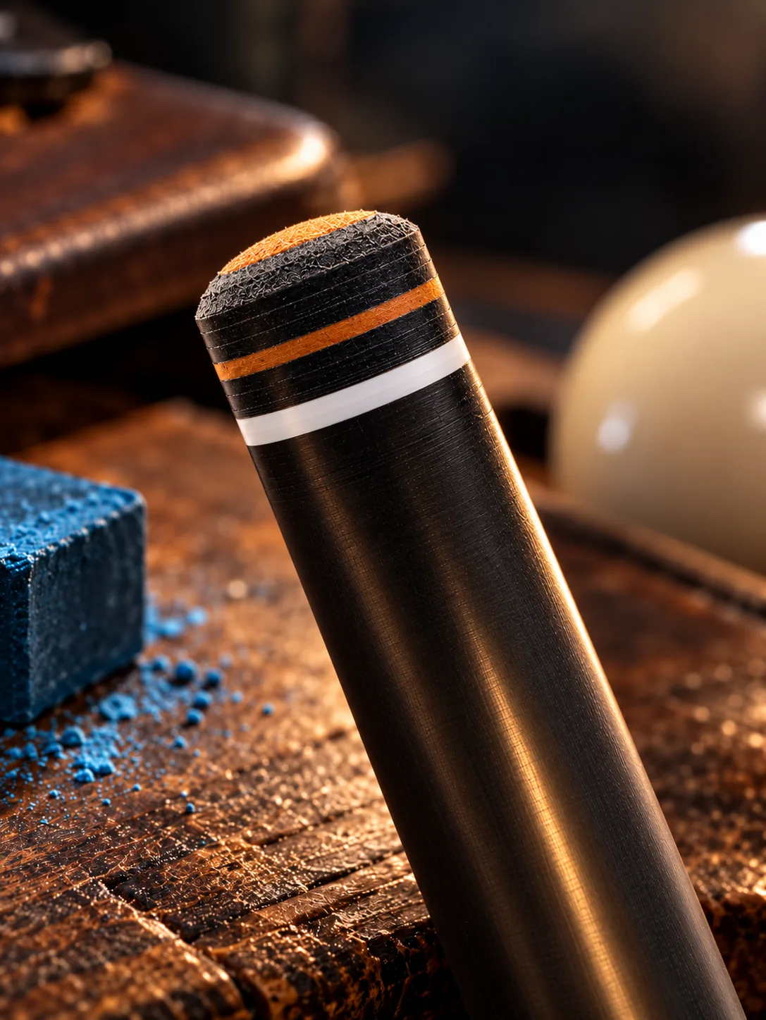 Installed Black Paladin Precision cue tip with a tan playing surface, fitted to a cue on a workbench